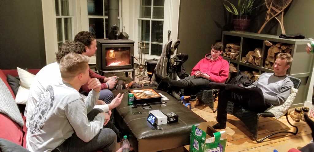 A group of friends enjoying a card game together in the common room at Hostel Tevere.